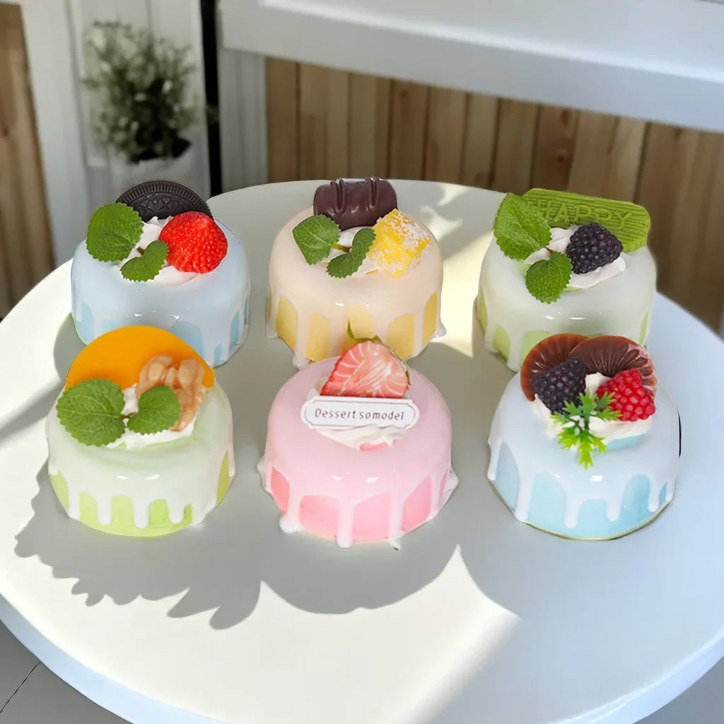 Set of colorful artificial fruit cake models with cream and decorative toppings for home decor