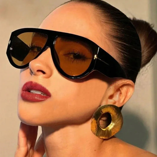 Woman wearing vintage oversized pilot sunglasses with large black frame and amber lenses for UV400 protection